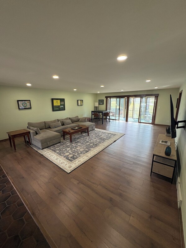 A spacious living room with a large sofa, a coffee table, and a dining area with chairs. - Spacious Ranch blocks away from downtown McHenry (McHenry)