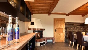 A cozy dining area with a wooden ceiling, a brick fireplace, and a bench. - Apartment in Schwalbenhof Farm (Sankt Stefan im Rosental)