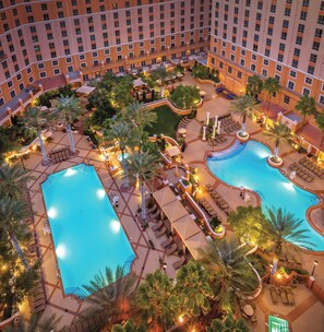 A hotel with two swimming pools, outdoor seating areas, and palm trees. - Wyndham Grand Desert 2 BR Deluxe- Full Resort Access 1 Mile off Vegas Strip! (Las Vegas)