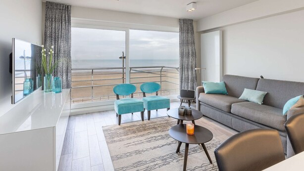 Een moderne woonkamer met een balkon, een bank, een salontafel en een televisie.
