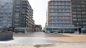 A beachfront building with multiple balconies, a sandy beach in front, and a clear sky. - Apartment in Nieuwpoort With Views (Nieuwpoort)