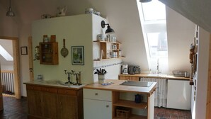 Une cuisine chaleureuse avec des meubles en bois, un îlot central et une fenêtre qui laisse entrer la lumière naturelle.