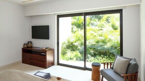 Ein Schlafzimmer mit einem Bett, einem Schreibtisch, einem Sessel und einem Fernseher.