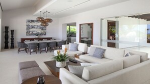 Ein modernes Wohnzimmer mit Sofa, Couchtisch und Essbereich.