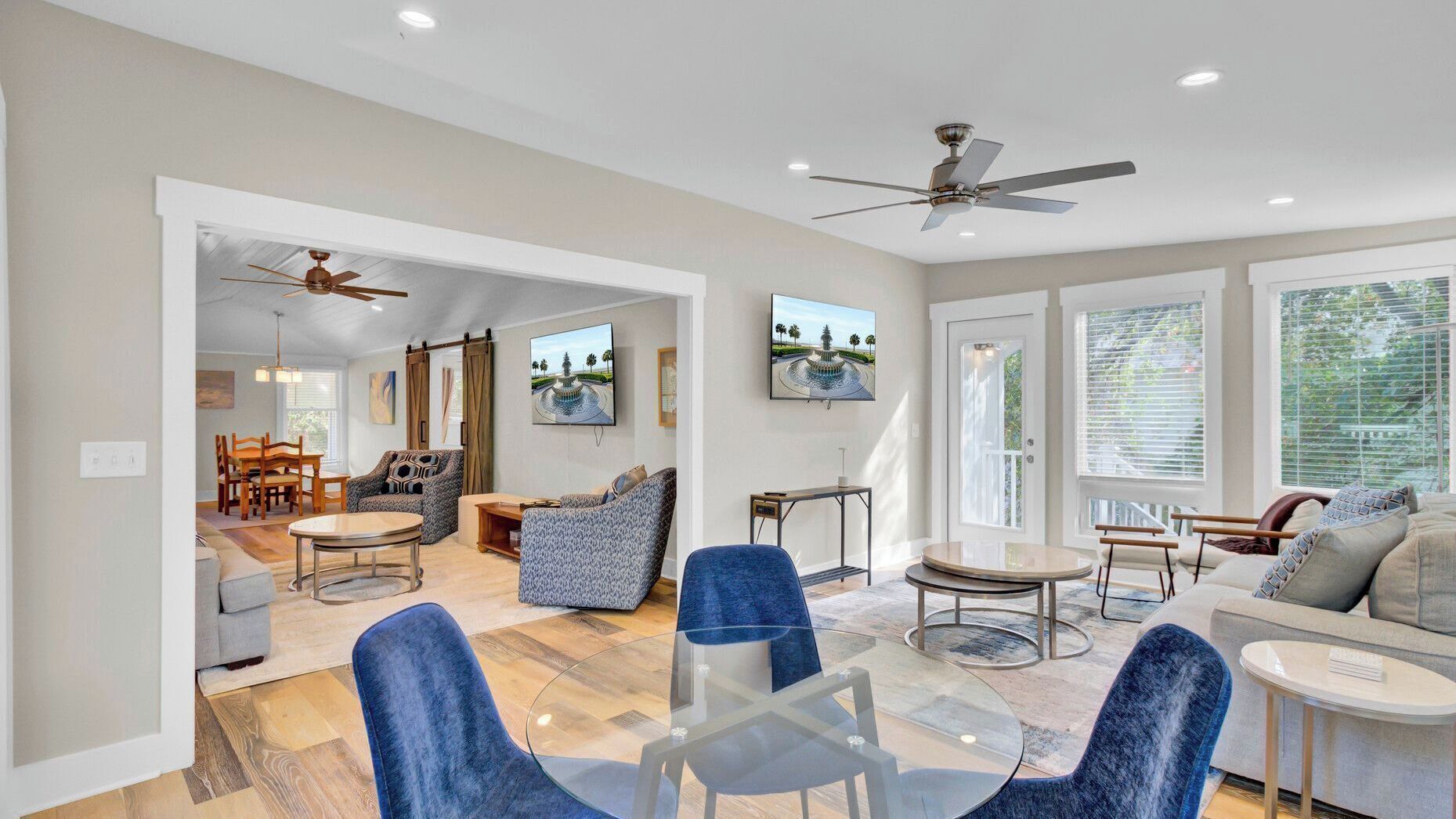 A spacious living area with a dining table, sofas, and a TV.