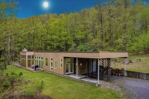 A modern house with a covered patio, large windows, and a view of a forested area. - Secluded + Modern Enclosed Patio, Forest Views Woodland Zen by Avantstay (Housatonic)