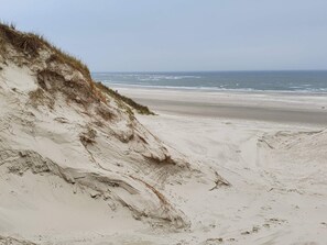 A beach with a sandy slope and a view of the ocean. - 4 Person Holiday Home in Blavand (Blavand)