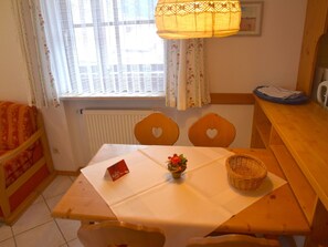 A cozy dining area with a table, chairs, a basket, and a small plant.