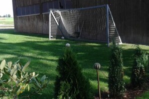 A soccer goal in a grassy area with a wooden building in the background. - Holiday Apartment Tulpe Schuniglhof (Neukirchen Beim Heiligen Blut)