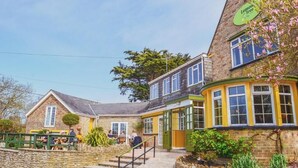 A traditional building with a stone facade, a green sign reading "Lemon Tree," and a small outdoor seating area with people. - Lemon Tree (Dorchester)