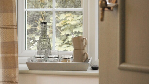 A room with a window, a bottle, and a tray with cups and plates. - Lemon Tree (Dorchester)