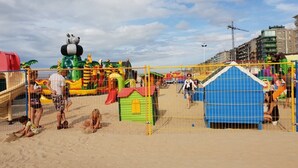 A beach playground with slides and play structures, surrounded by a fence. - Apartment Near Dunes in Koksijde (Koksijde)