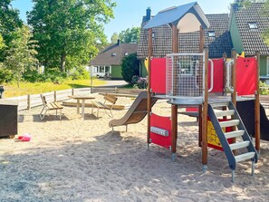 A playground with a slide, climbing structure, and benches. - 4 Star Holiday Home in Vastervik (Vastervik)