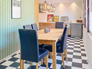 A dining area with a checkered floor, a wooden table, and black upholstered chairs. - 4 Star Holiday Home in Vastervik (Vastervik)