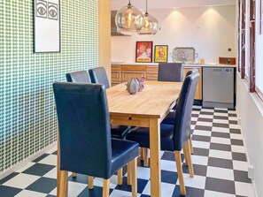 A dining area with a checkered floor, a wooden table, and black upholstered chairs. - 4 Star Holiday Home in Vastervik (Vastervik)