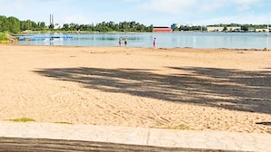 Une plage de sable avec une clôture en bois au premier plan.