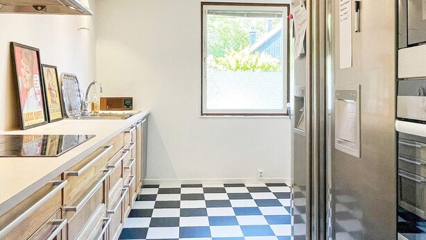A kitchen with a checkered floor, a window, and a refrigerator. - 4 Star Holiday Home in Vastervik (Vastervik)