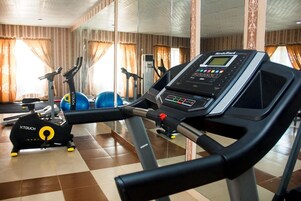 Uma academia com esteiras, bicicletas ergométricas e bolas de exercício.