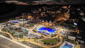 An aerial view of a resort with multiple swimming pools, a golf course, and a large parking area. - Luxury Chalet | Indoor pool | Hot Tub | Game Room (Sevierville)