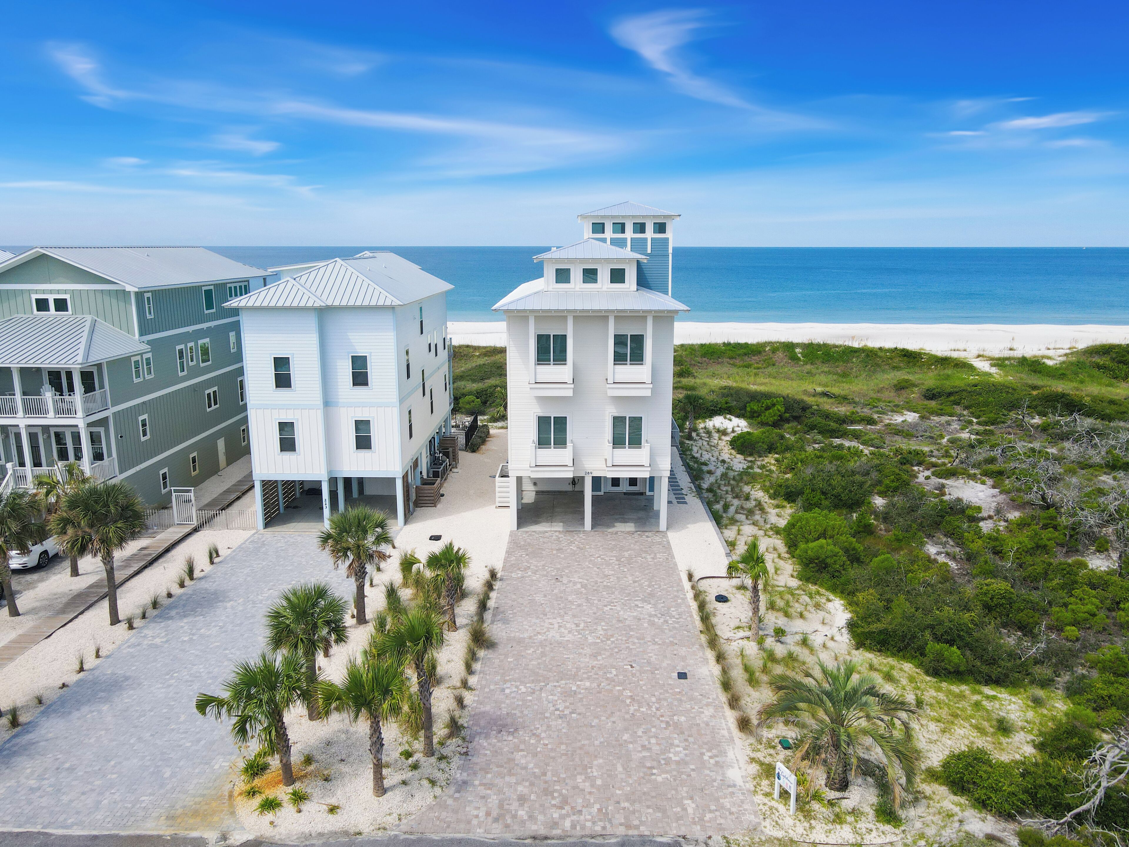 Un hôtel situé en bord de mer, composé de plusieurs bâtiments, doté d’une promenade dallée et offrant une vue sur l’océan.
