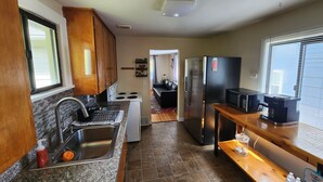 A compact kitchen with a stove, sink, and refrigerator.