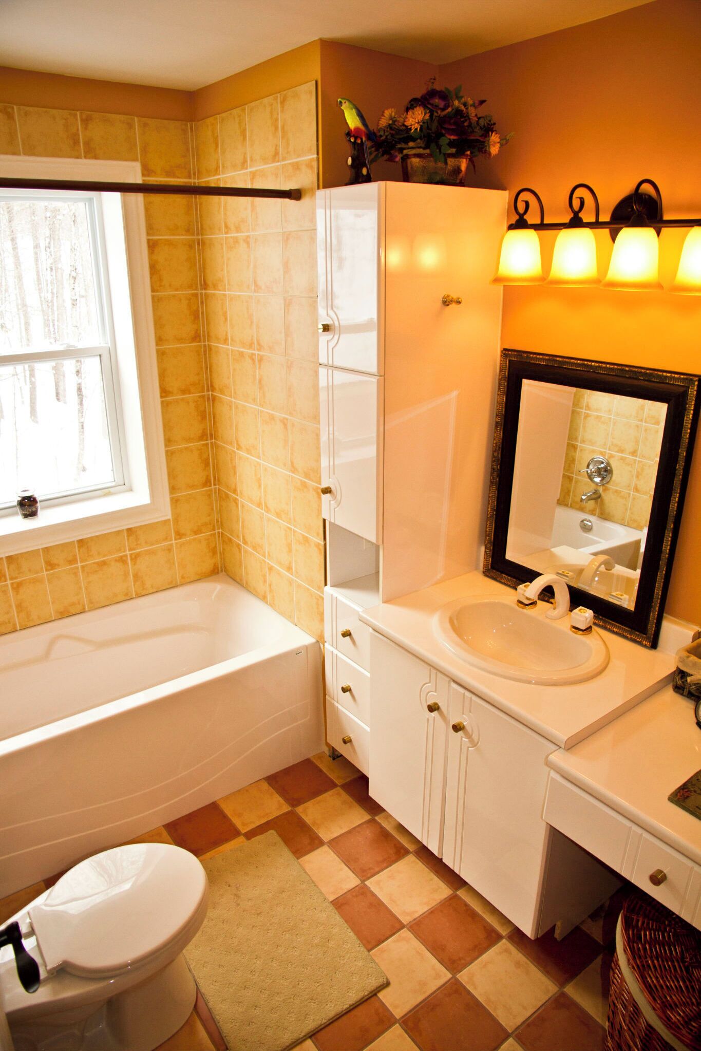 A bathroom with a white bathtub, a sink with a mirror, and a window.