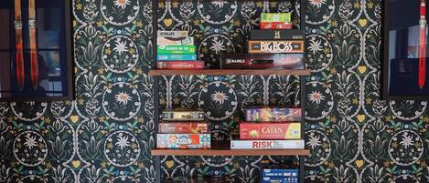 A bookshelf with various board games and a Jenga tower.