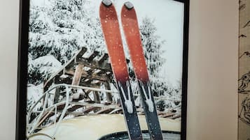 A framed picture of a vintage car with skis on the roof, set against a snowy landscape.