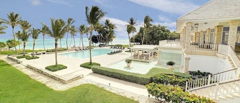 Et resort med pool, palmer og en bygning med trappe.