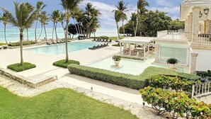 A resort with a swimming pool, palm trees, and a view of the ocean. - HDM 333 - Golf View Apartment in Exclusive Resort Access to Private Beaches (Punta Cana)