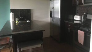 A compact kitchen with a refrigerator, microwave, and stove. - Private Deck Paradise  (Brooklyn)