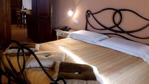 A bedroom with a bed, pillows, a bedside table, a lamp, and a painting of daisies on the wall. - Casa Vacanze a Bettona con Giardino (Bettona)