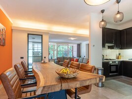 Una cocina moderna con armarios oscuros, una isla grande con asientos e iluminación colgante.
