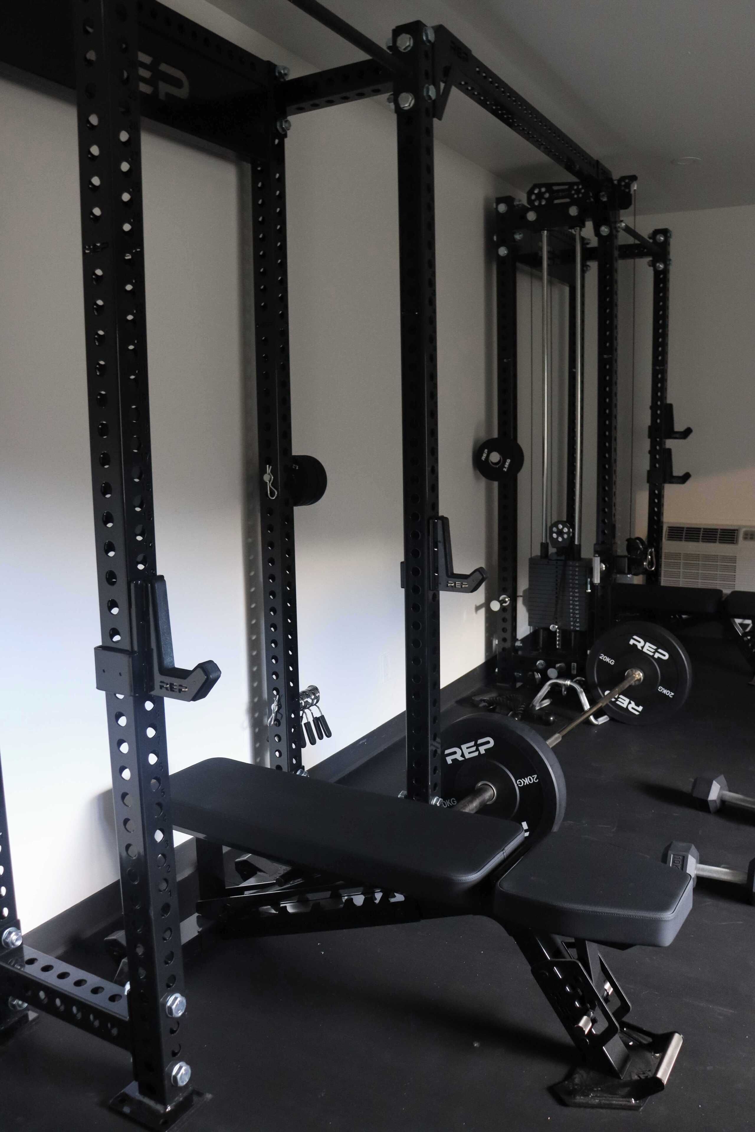 Ein Fitnessraum mit Hantelbank, Squat-Rack und Gewichtsplatten.