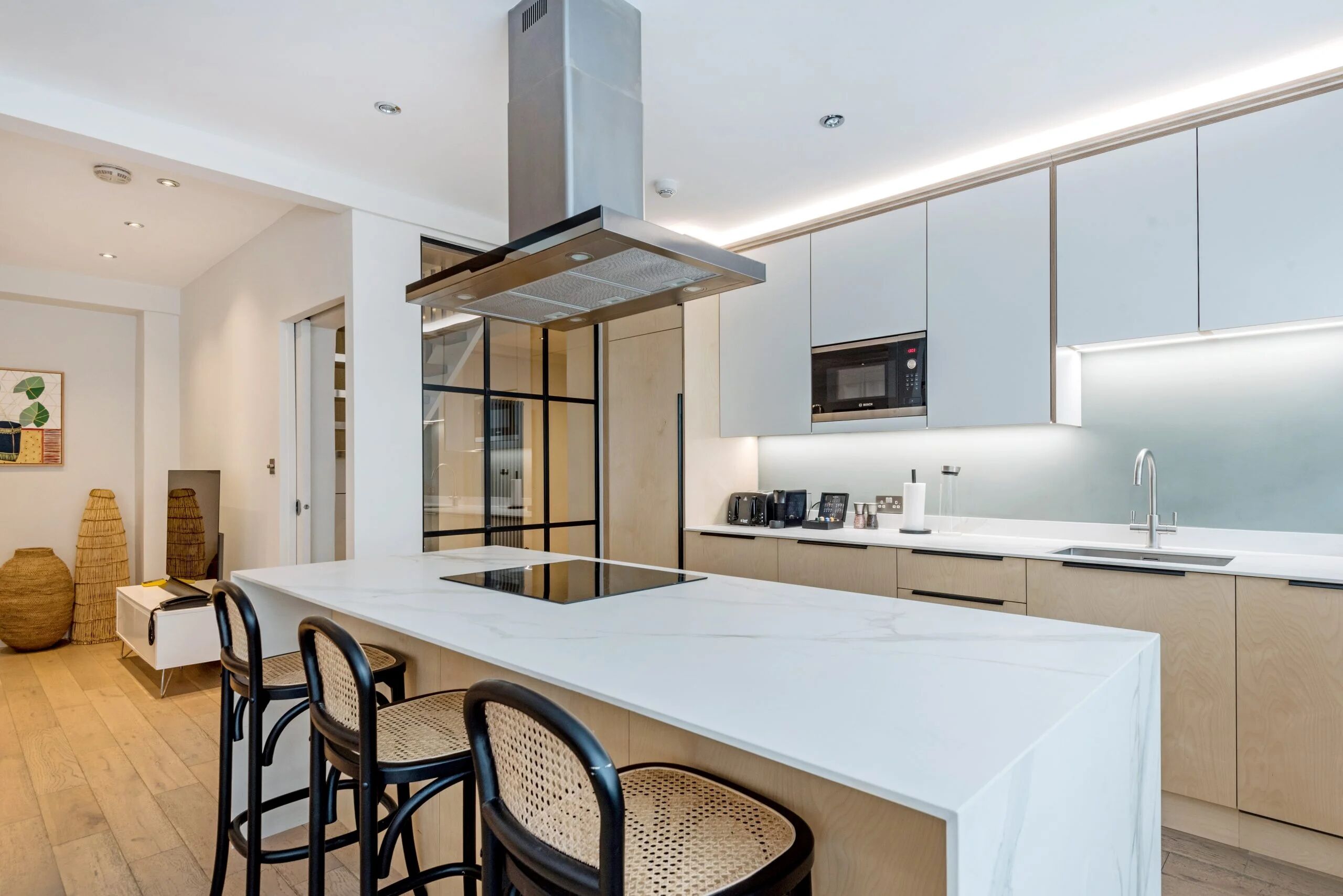 A modern kitchen with a central island, built-in appliances, and a minimalist design.