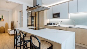 A modern kitchen with a central island, built-in appliances, and a minimalist design.