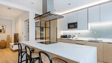 A modern kitchen with a central island, built-in appliances, and a minimalist design.