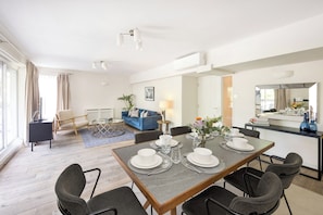 Una sala moderna con comedor, sofá y mostrador de cocina.