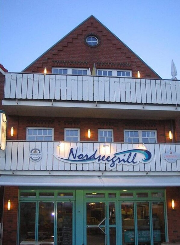A two-story building with a sign reading "Nordseegill." - North Beach Modern Retreat (Borkum)