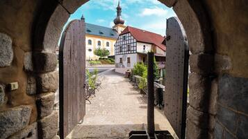 An archway leading to a courtyard with a building in the background.