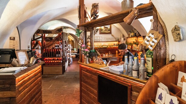 Un rincón de bar acogedor y rústico con muebles de madera, una bodega y varias botellas.