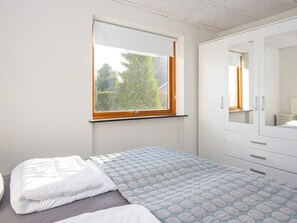 A bedroom with a bed, a window, and a wardrobe. - 4 Person Holiday Home in Haderslev (Haderslev)