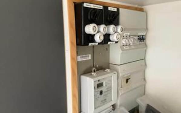 A utility room with electrical panels, a control panel, and labeled boxes. - 4 Person Holiday Home in Haderslev (Haderslev)