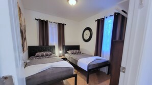 A bedroom with two beds, a clock on the wall, and a window with curtains. - Beverlywood 2 bedroom guesthouse. 5 minutes to Rodeo Drive!  (Beverly Hills)