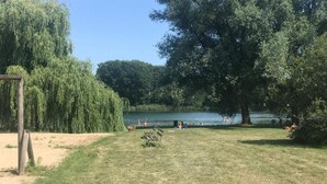 A park with a lake, benches, and trees. - Forest Villa With Private Terrace (Ewijk)