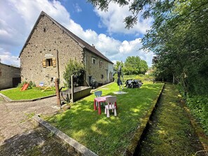 A stone building with a grassy yard, a red slide, and a picnic table. - Country house with swimming pool (Chaillac)