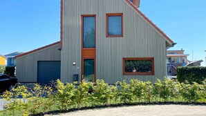 A modern building with a sloped roof, vertical siding, and a garage door. - Water Villa in Heeg by Heegermeer (Heeg)