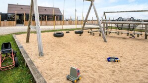 A playground with swings, tire swings, and a tire car. - 6 Person Holiday Home in Thyholm (Thyholm)