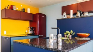 A kitchen with a central island, a red refrigerator, and a coffee machine. - 6 Person Holiday Home in Thyholm (Thyholm)