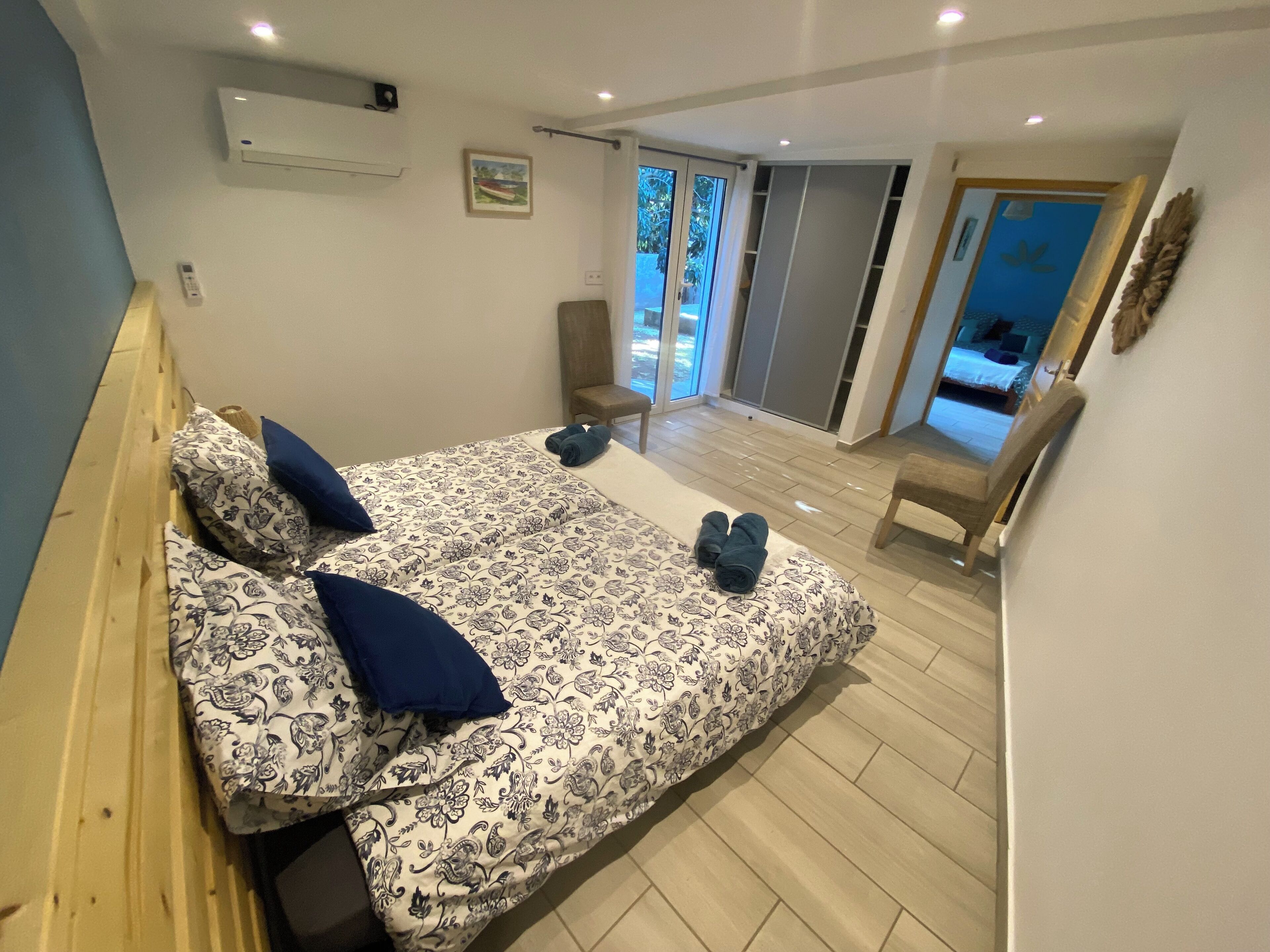 Une chambre à coucher avec un lit, une chaise et une vue sur l’extérieur.